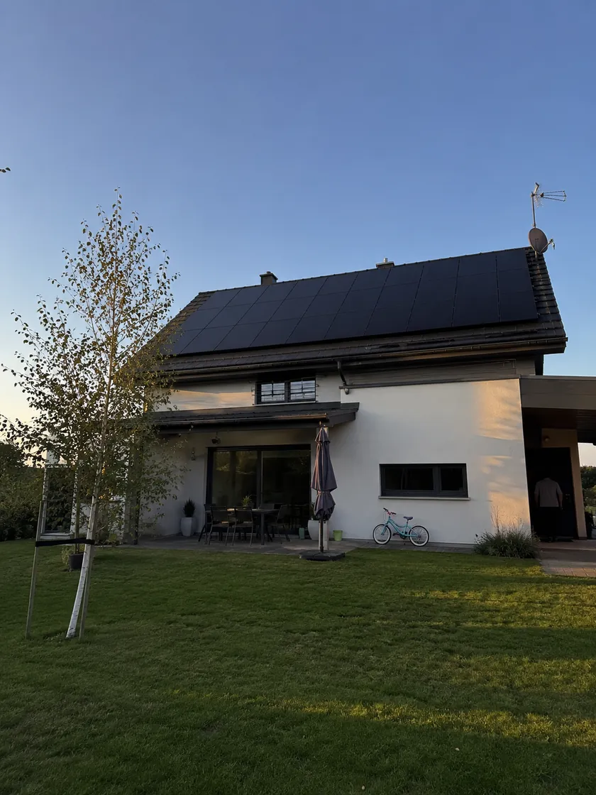 Dom jednorodzinny z instalacją fotowoltaiczną na dachu, widok od strony ogrodu